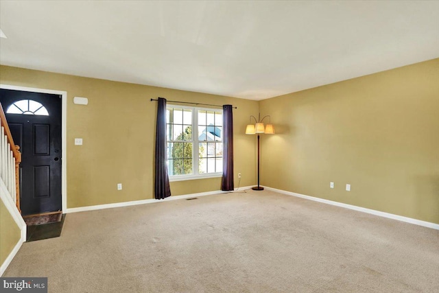 entrance foyer featuring visible vents, baseboards, stairs, and carpet