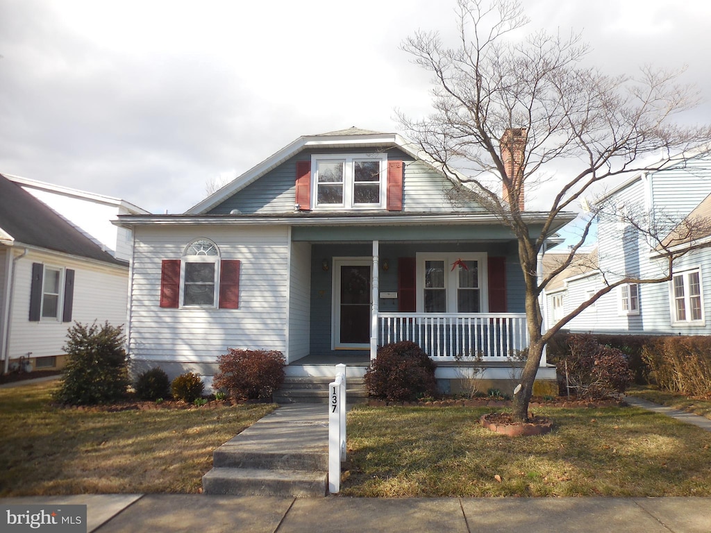 bungalow-style house with a porch and a front lawn