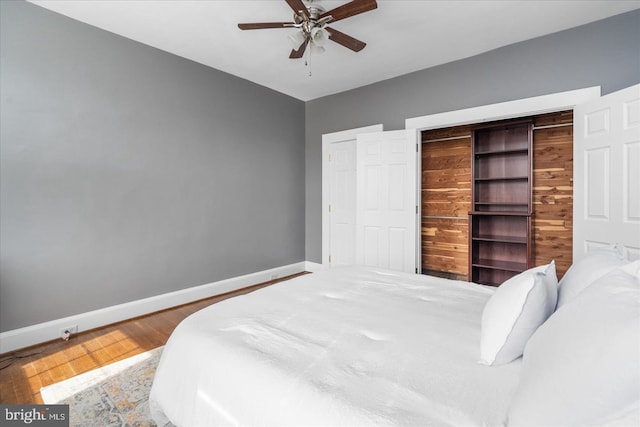 bedroom with wood finished floors, a ceiling fan, and baseboards