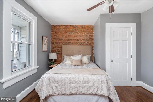 bedroom with ceiling fan, wood finished floors, and baseboards