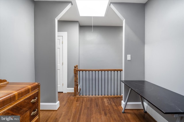 corridor with wood finished floors and baseboards