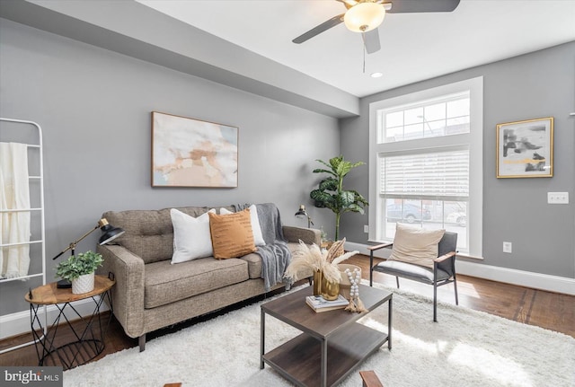 living room featuring wood finished floors, a ceiling fan, and baseboards