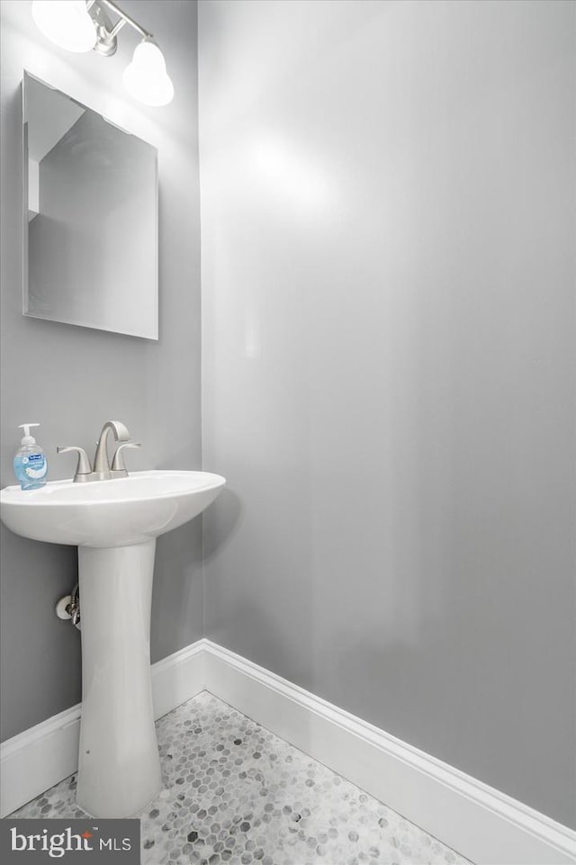 bathroom featuring a sink and baseboards