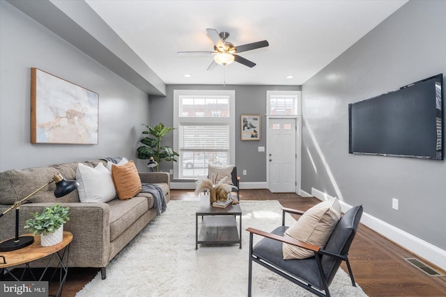 living room with recessed lighting, wood finished floors, visible vents, and baseboards