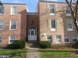 view of property featuring entry steps and brick siding