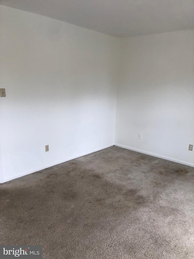 empty room featuring dark carpet