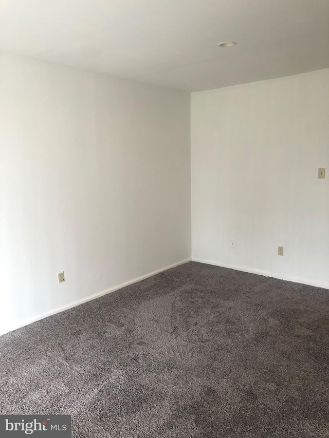 carpeted spare room with baseboards