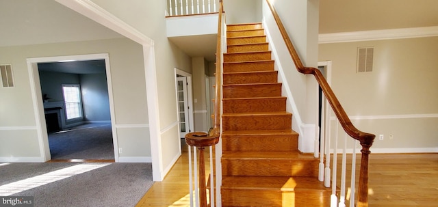 20153 Valhalla Sq, Ashburn, VA 20147 - staircase with a fireplace, wood finished floors, baseboards, visible vents, and carpet