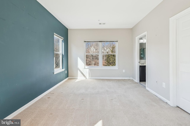 carpeted empty room with visible vents and baseboards