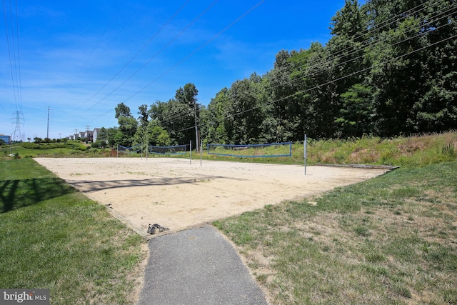 surrounding community with a lawn and volleyball court