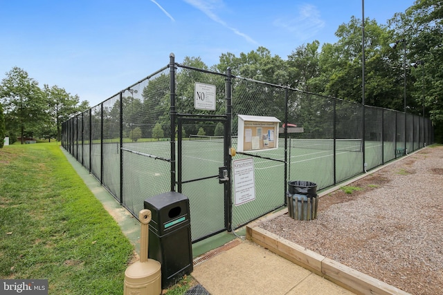 view of tennis court featuring a gate and fence