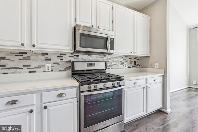 kitchen with stainless steel appliances, light countertops, white cabinetry, and decorative backsplash