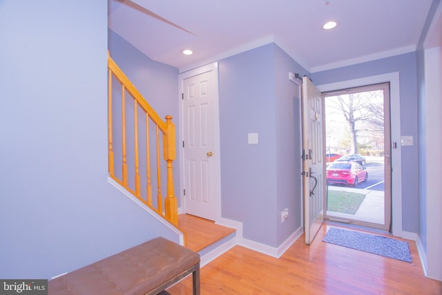 entryway with light wood-type flooring, stairs, baseboards, and recessed lighting