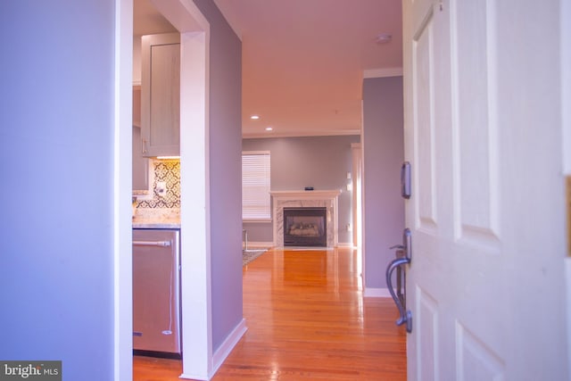 hallway with light wood-style flooring, baseboards, and recessed lighting