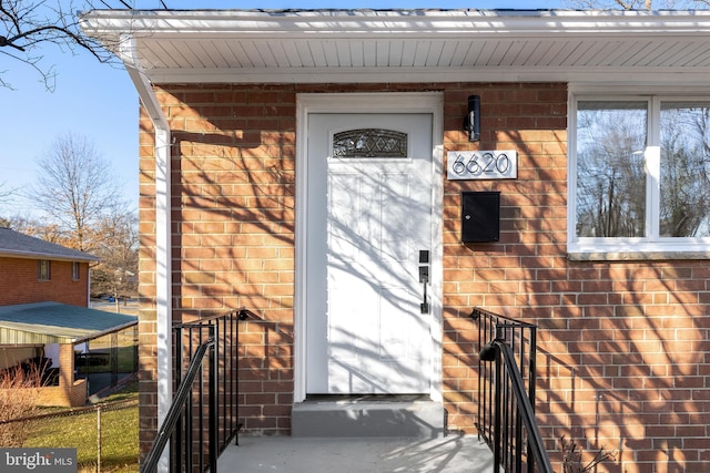 entrance to property featuring brick siding