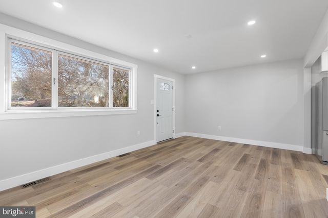 interior space with light wood-style floors, baseboards, visible vents, and a wealth of natural light