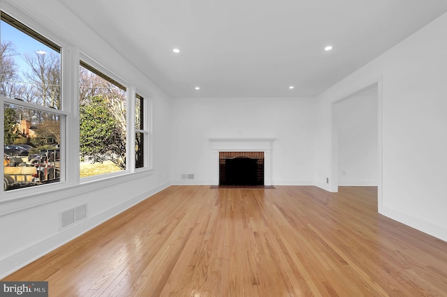 unfurnished living room featuring visible vents, baseboards, a fireplace, recessed lighting, and light wood-style floors