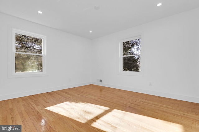 spare room with recessed lighting, baseboards, and wood finished floors