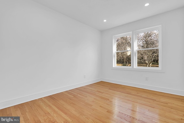 spare room featuring recessed lighting, baseboards, and light wood finished floors