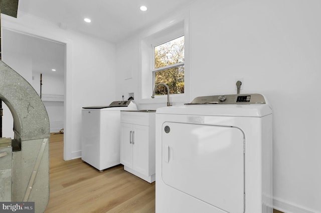 laundry room with recessed lighting, cabinet space, light wood-style flooring, and washer and clothes dryer