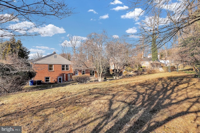 view of side of property featuring a yard and brick siding