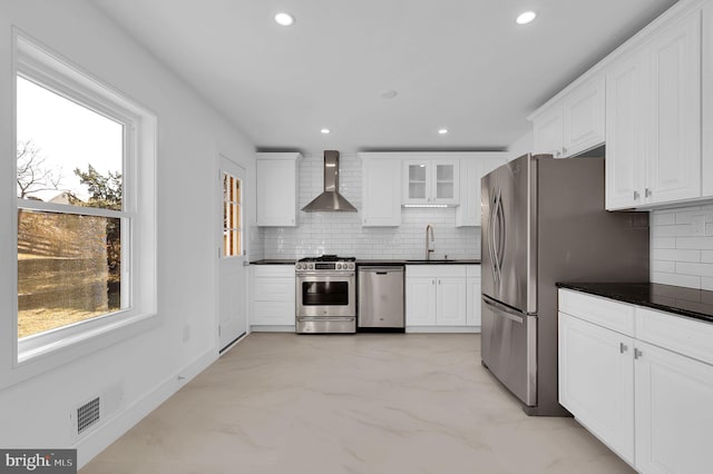 kitchen with dark countertops, visible vents, appliances with stainless steel finishes, and wall chimney exhaust hood