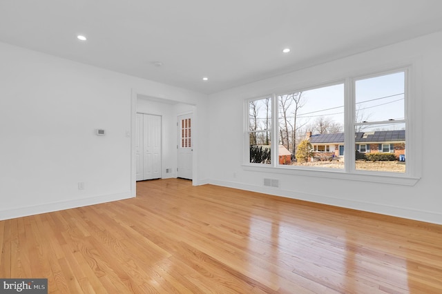 empty room featuring recessed lighting, visible vents, light wood-style flooring, and baseboards