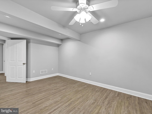 basement with baseboards, visible vents, ceiling fan, and wood finished floors