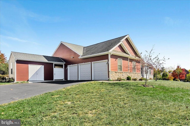 view of front of house featuring a shingled roof, a garage, stone siding, driveway, and a front lawn