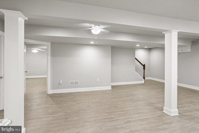 finished basement featuring stairway, ceiling fan, visible vents, and light wood-style flooring