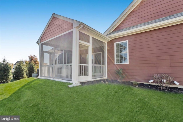 view of side of property with a yard and a sunroom