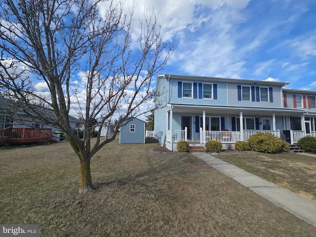 view of front of home with an outbuilding, a storage unit, a front lawn, and covered porch