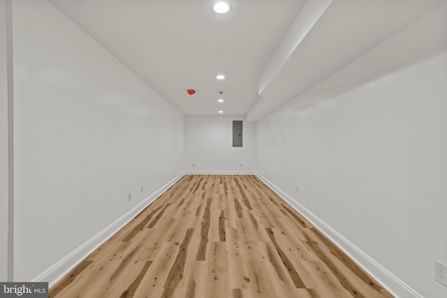 spare room featuring light wood-style flooring, electric panel, baseboards, and recessed lighting