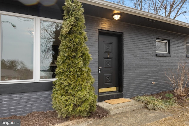 doorway to property with brick siding