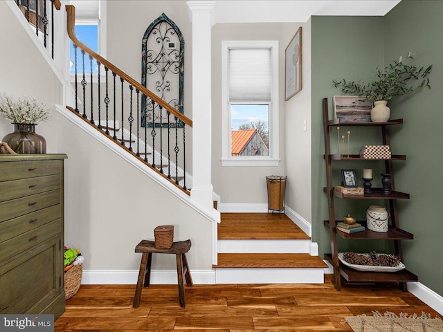 stairs featuring wood finished floors and baseboards