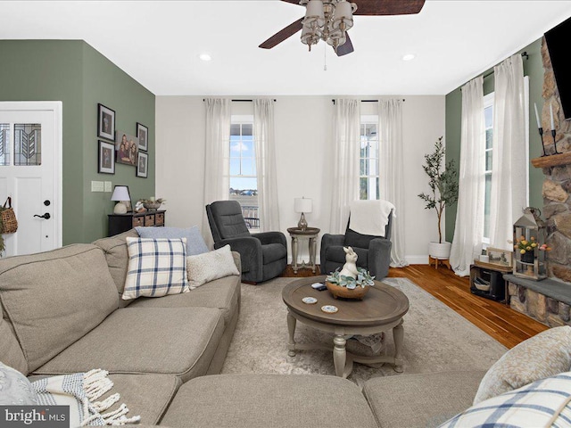 living room featuring ceiling fan, baseboards, wood finished floors, and recessed lighting