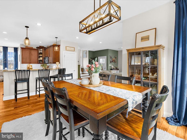 dining area with light wood-style flooring, baseboards, and recessed lighting