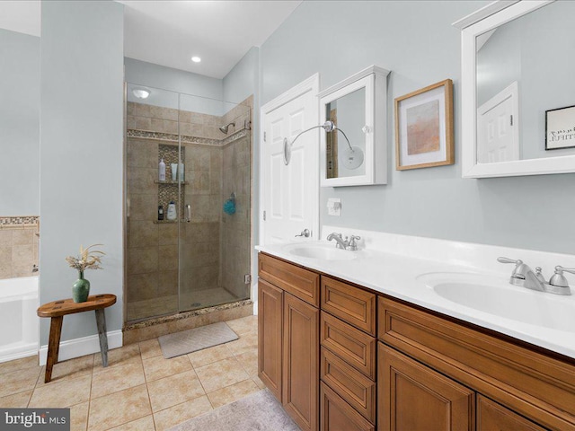 bathroom featuring double vanity, tile patterned flooring, a shower stall, and a sink