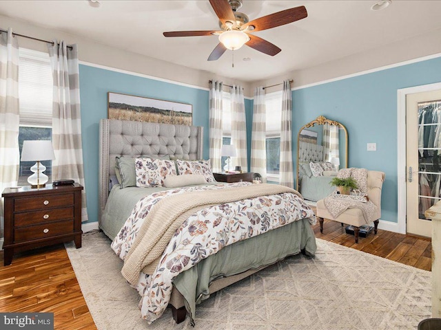 bedroom with hardwood / wood-style floors, multiple windows, and a ceiling fan