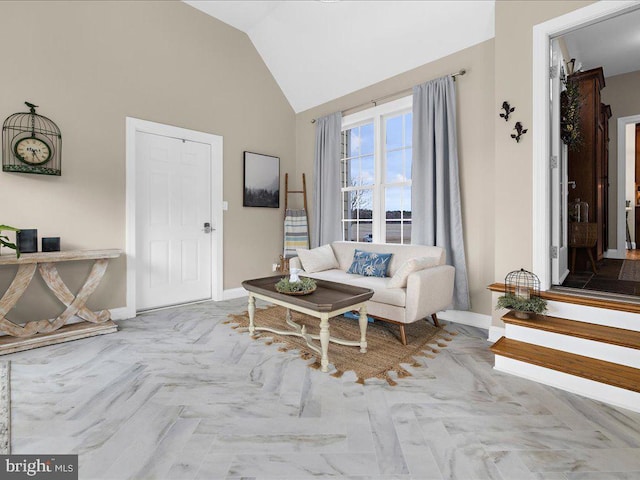 living area with baseboards and vaulted ceiling