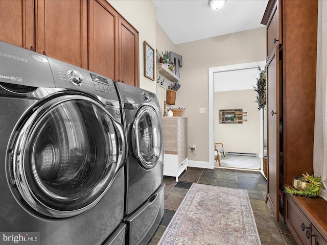 washroom with baseboards, washer and clothes dryer, cabinet space, and stone tile floors