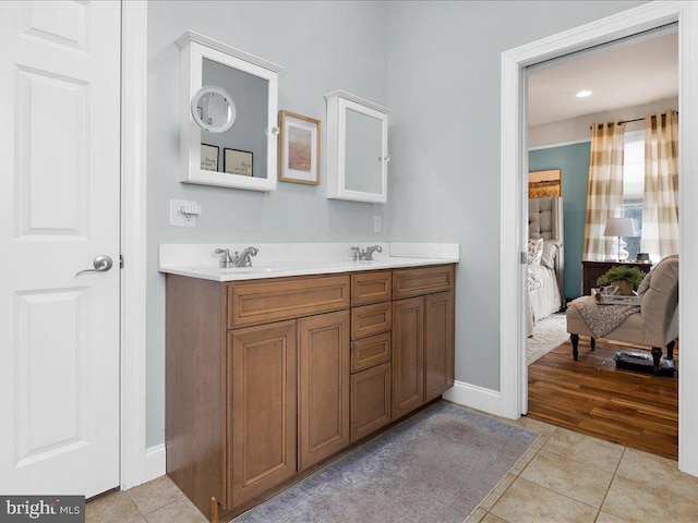 bathroom featuring a sink, double vanity, ensuite bath, and tile patterned flooring