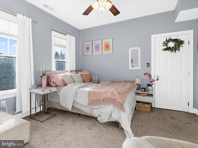 carpeted bedroom featuring visible vents and a ceiling fan