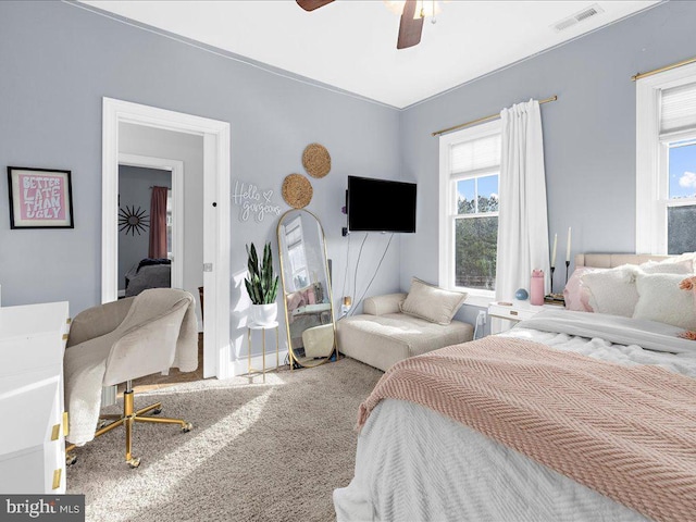 bedroom with carpet, visible vents, and a ceiling fan