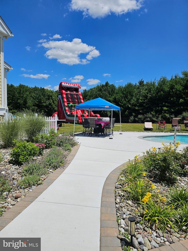 surrounding community featuring a patio area, fence, and a swimming pool