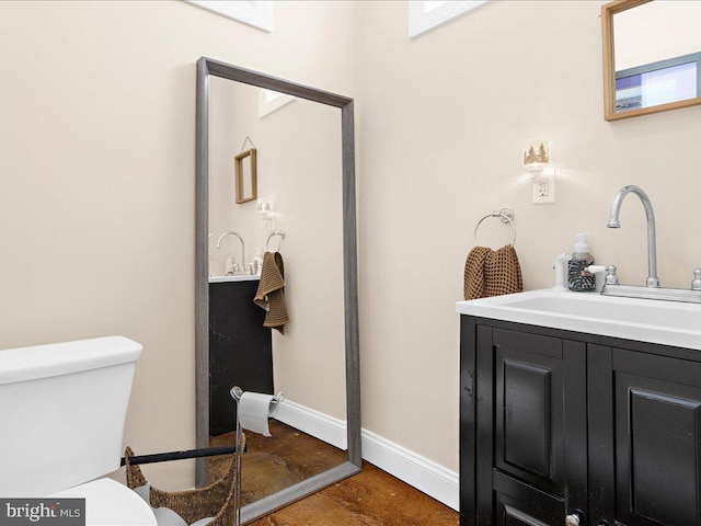 bathroom with toilet, baseboards, and vanity