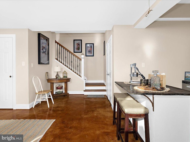 interior space with dark countertops, finished concrete floors, and baseboards