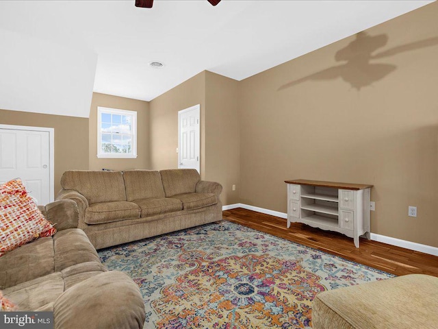 living area with visible vents, ceiling fan, baseboards, and wood finished floors