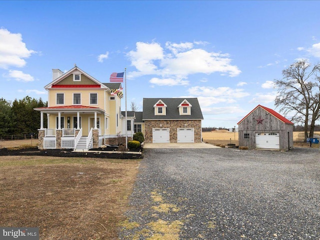 view of front of home with a garage, covered porch, an outdoor structure, and stone siding