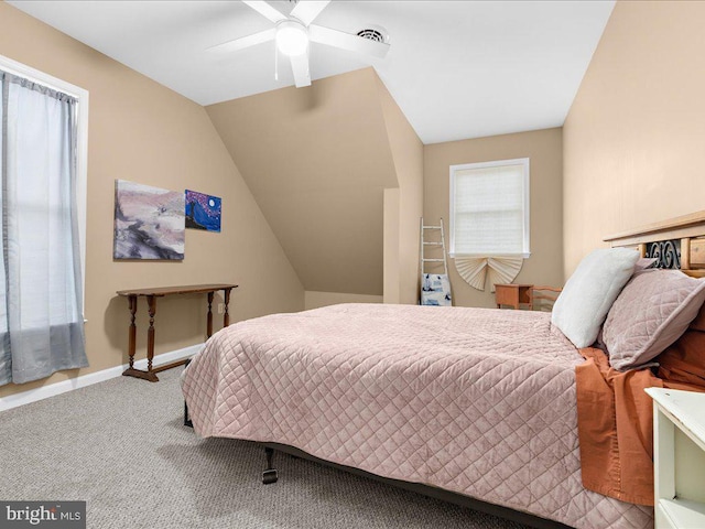 carpeted bedroom featuring lofted ceiling, visible vents, a ceiling fan, and baseboards